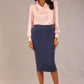 Model wearing a pink satin pebble top with a cowl neck and long sleeves, styled with a navy pencil skirt