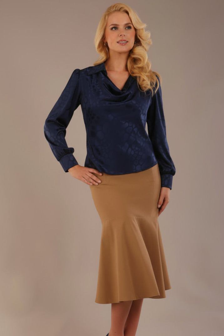 Blonde Model wearing the Shropshire top in navy blue, styled with a camel flared fishtail skirt