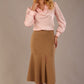 Model wearing a tanin brown Marlene fishtail skirt with a light pink top.