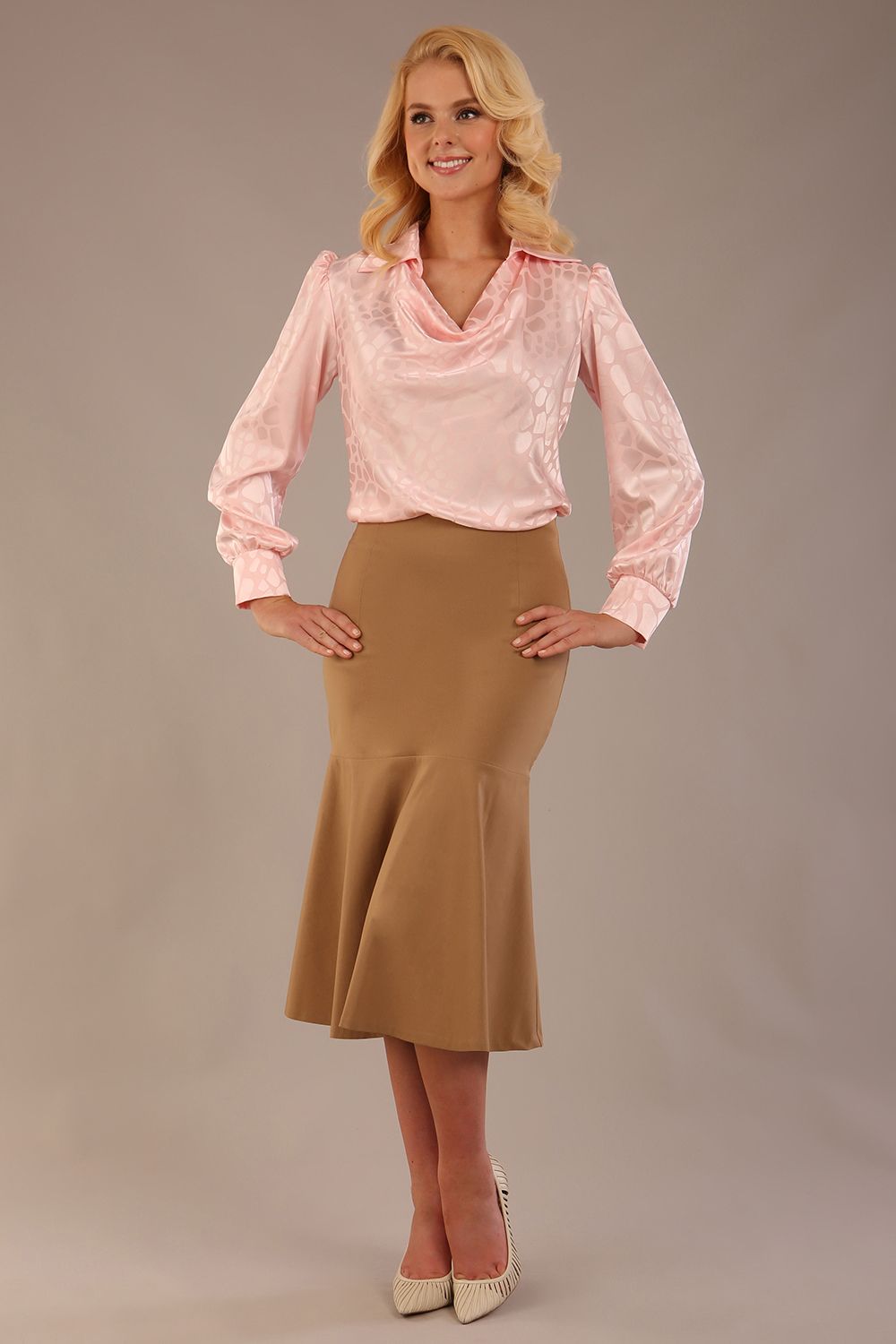 Model wearing a tanin brown Marlene fishtail skirt with a light pink top.