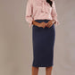 Model wearing a pink satin pebble top with a tie neckline and 3/4 sleeves, styled with a navy pencil skirt.