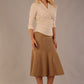 Model wearing a Trina wrap top in almond cream, with a wide V-neck and 3/4 sleeves, styled with a camel fishtail skirt.