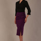 Model wearing a Trina wrap top in black, with a wide V-neck and 3/4 sleeves, styled with a purple pencil skirt.