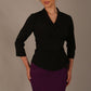 Model wearing a Trina wrap top in black, with a wide V-neck and 3/4 sleeves, styled with a purple pencil skirt front view