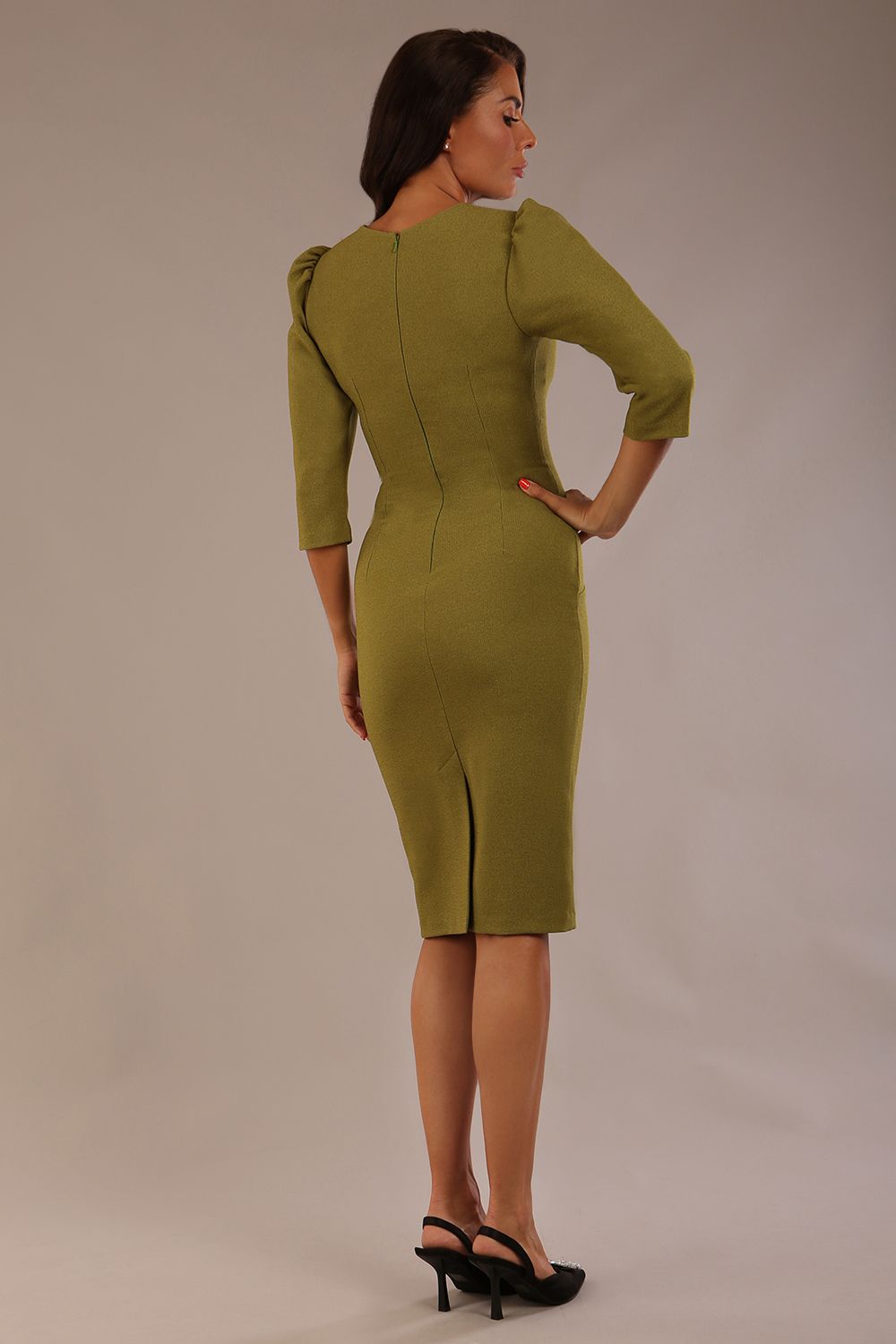 Model wearing an Ethan V-neck dress in oasis green, highlighting the flattering seams and puff shoulders back view