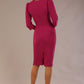 Model wearing an Ethan V-neck pencil dress in festive fuchsia, with 3/4 sleeves and puff shoulders back view
