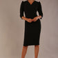 Model wearing a black Ethan pencil dress with a crossover V-neck and tailored seams.
