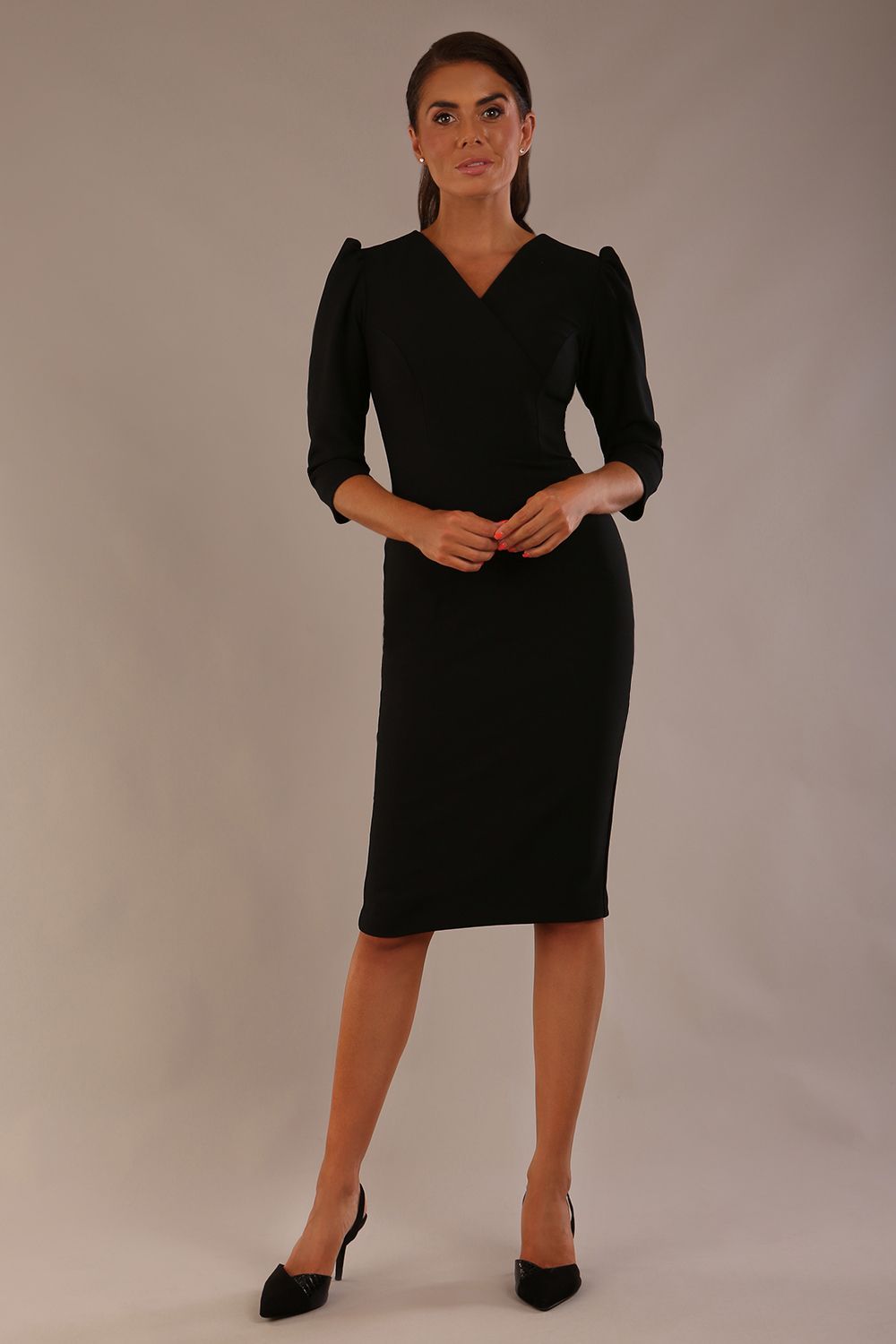 Model wearing a black Ethan pencil dress with a crossover V-neck and tailored seams.