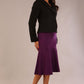 Full-length view of the Teddy jacket in black paired with a matching fishtail skirt in purple.