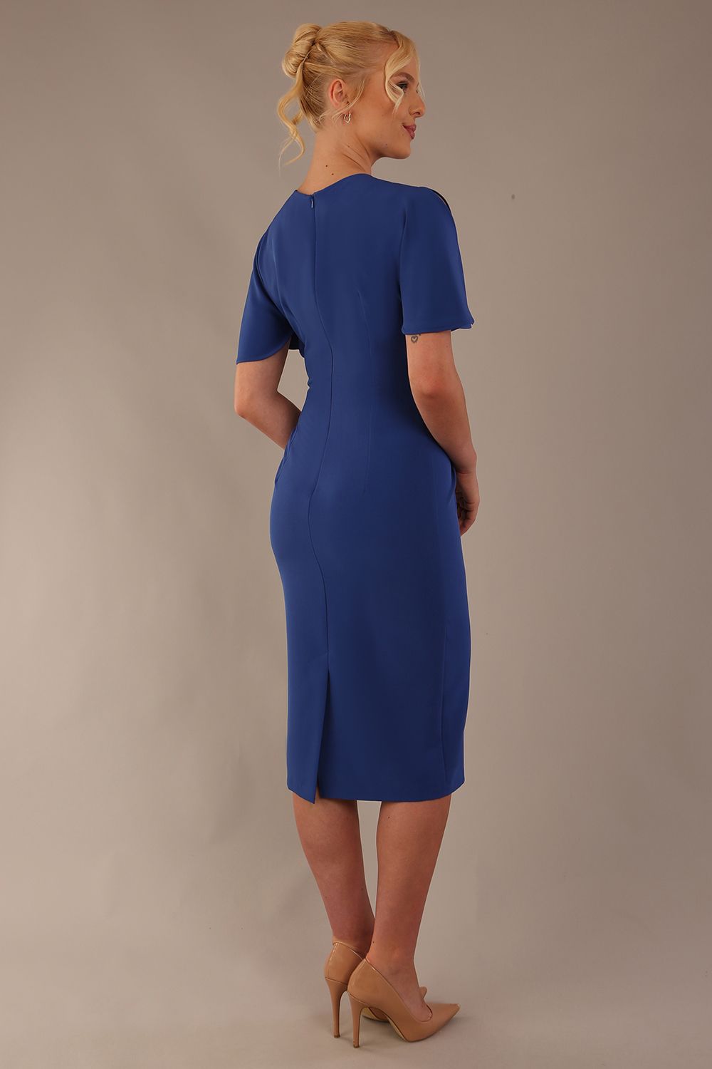 Model wearing nautical blue Finley midi pencil dress with ruched waist and split sleeves, back view.