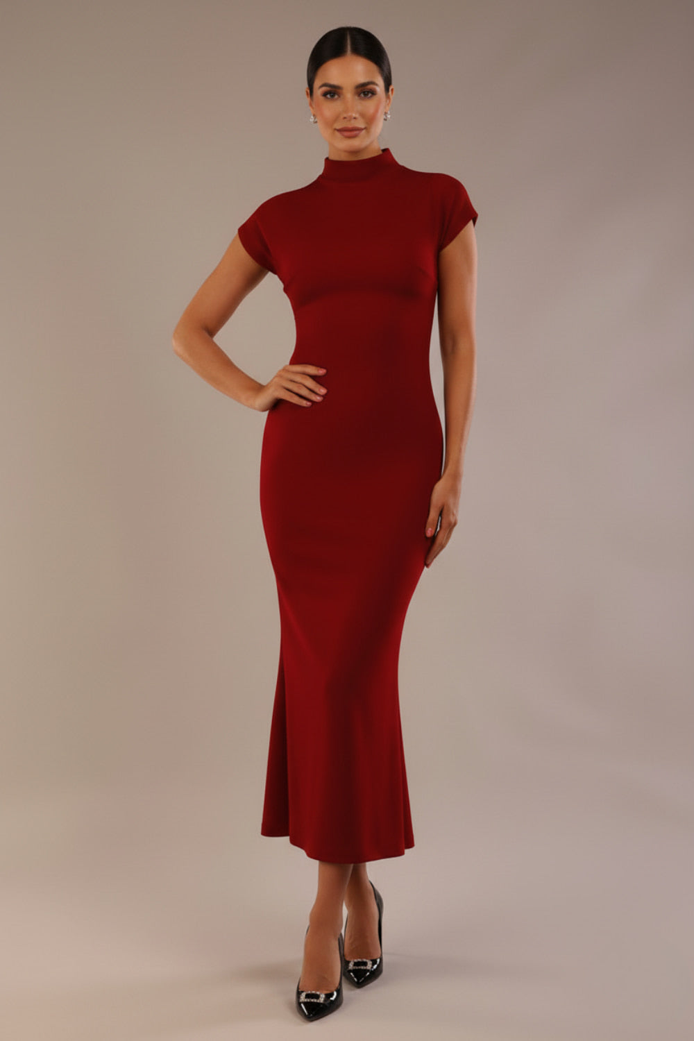 Model wearing the Kaden high neck midaxi dress in claret red, showing the sleek silhouette and cap sleeves against a plain background