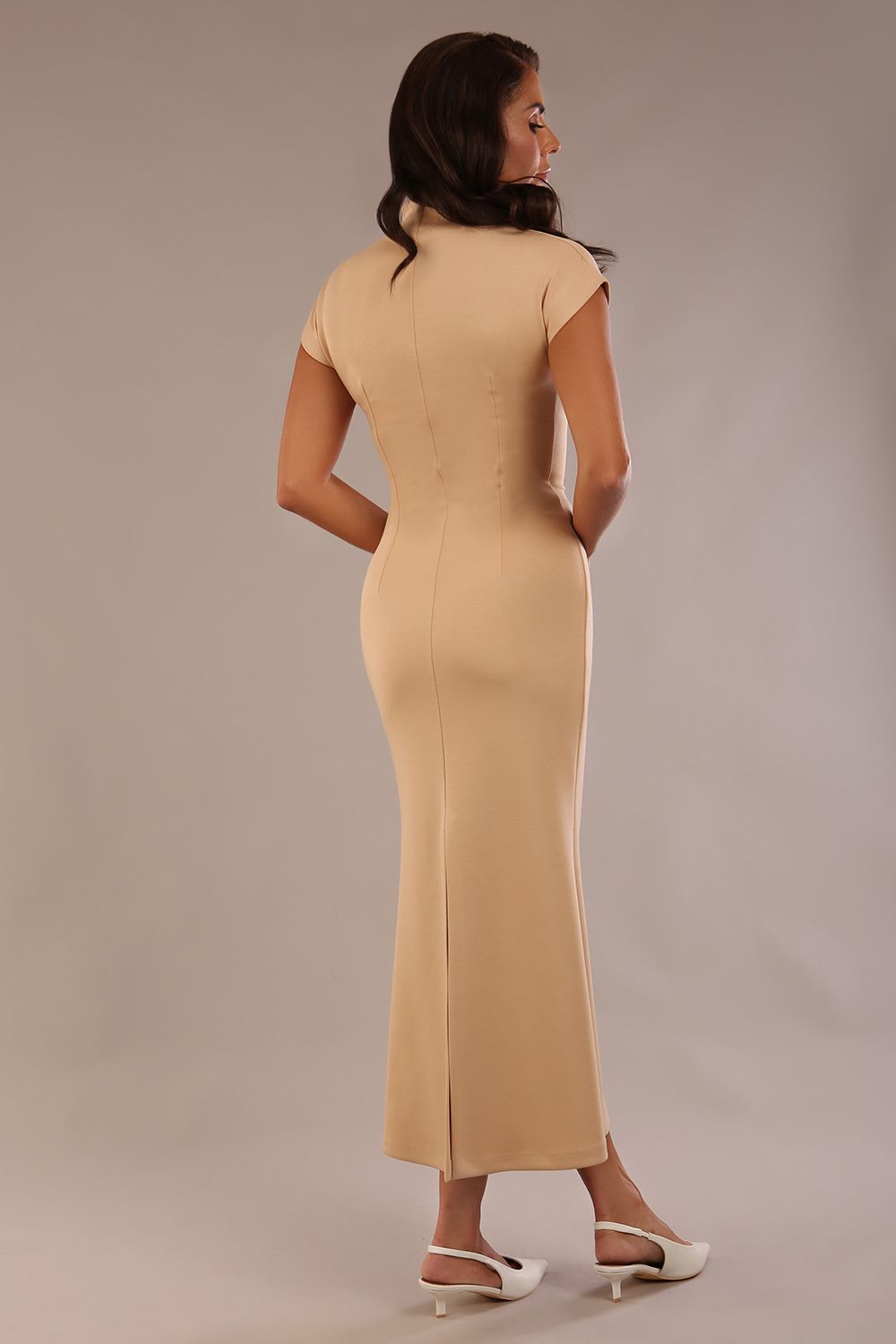 Model wearing the Kaden high neck midaxi dress in cafe au lait cream, showing the sleek silhouette and cap sleeves. against a plain background back view