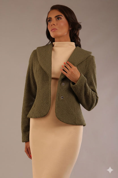 Model wearing the Teddy Luxe Boucle Jacket in oive green, styled over a cream pencil dress close up (Olive Green)
