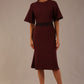 Model wearing the Lovell dress in port royale, showcasing the fluted sleeves and black lace waistband against a beige background