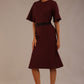 Model wearing the Lovell dress in port royale, showcasing the fluted sleeves and black lace waistband against a beige background