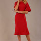 Model wearing the Lovell dress in salsa red, showcasing the fluted sleeves and black lace waistband against a beige background