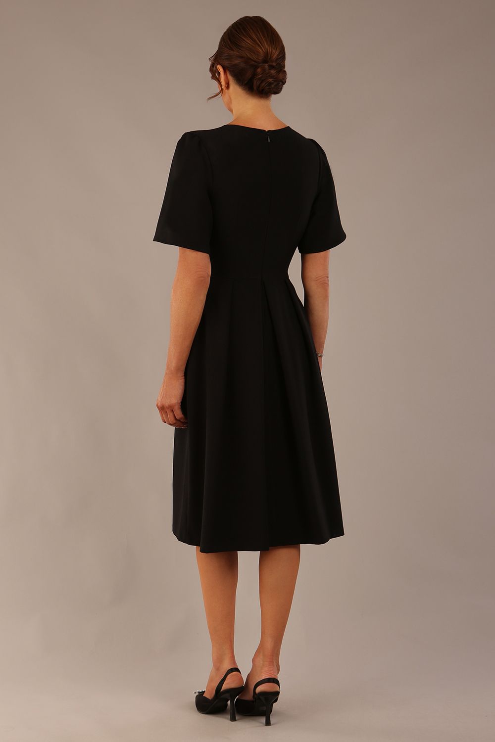 Model wearing the Dale pleated A-line dress against a plain background (Black)