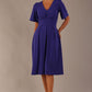 Model wearing the Dale pleated A-line dress against a plain background (Spectrum Indigo)