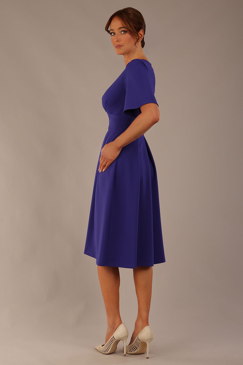 Model wearing the Dale pleated A-line dress against a plain background (Spectrum Indigo)