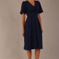 Model wearing the Dale pleated A-line dress against a plain background (Navy Blue)