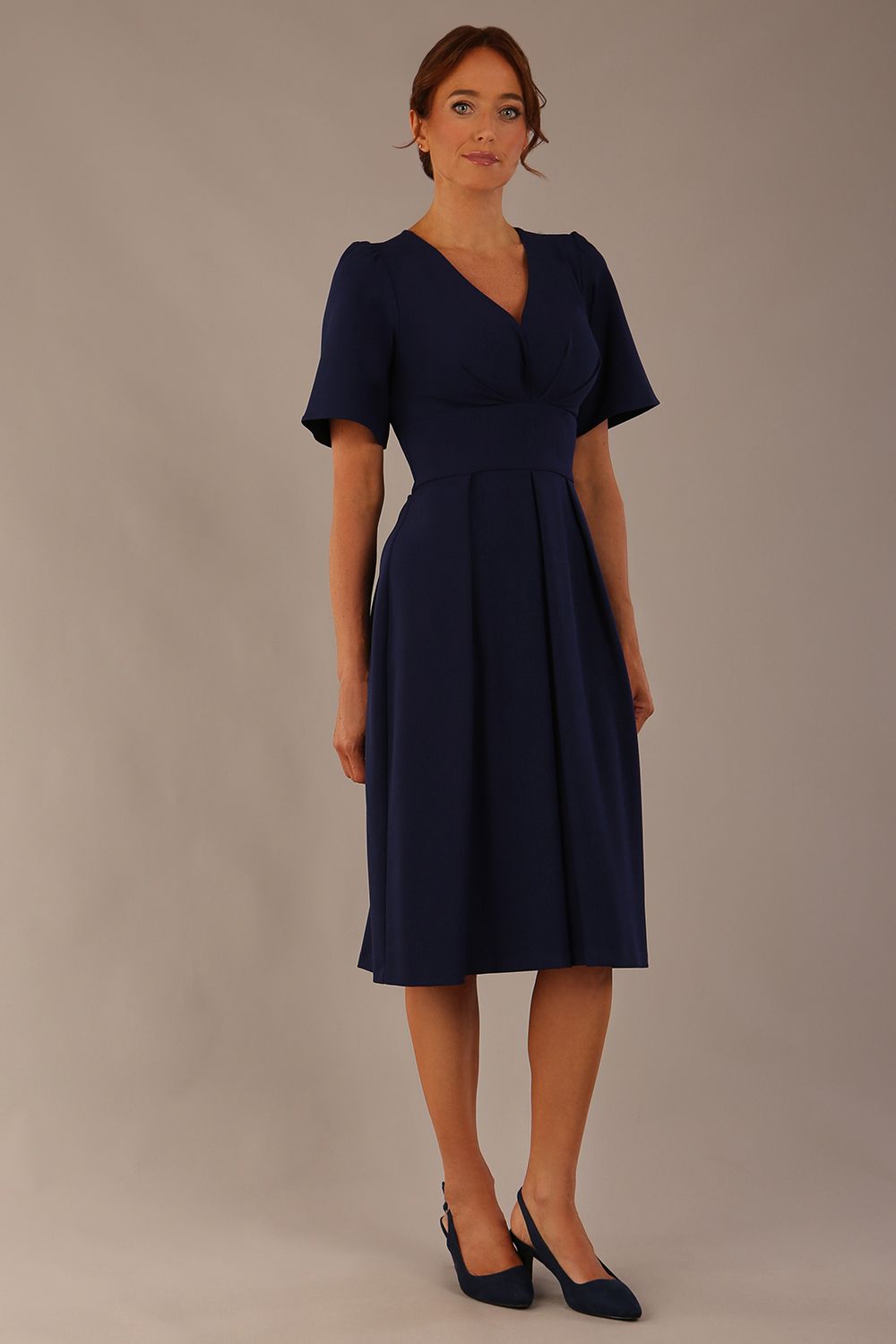 Model wearing the Dale pleated A-line dress against a plain background (Navy Blue)