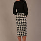Woman wearing a diva catwalk cressida black top and houndstooth skirt against a neutral background back view