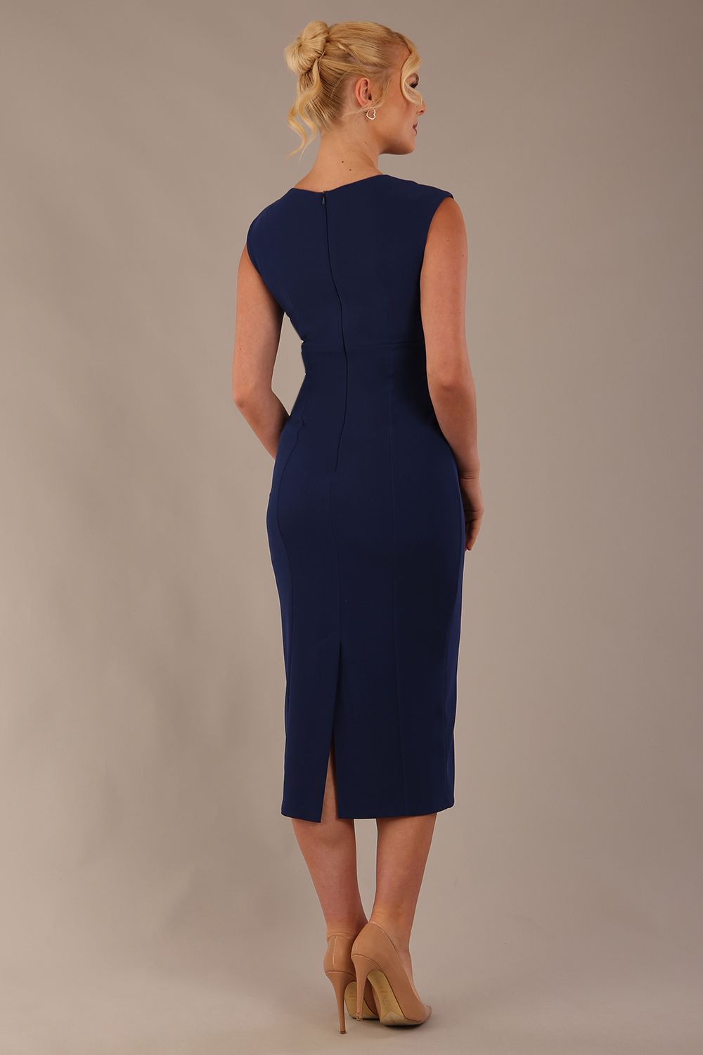 Model wearing the Wesley notched pencil dress in navy blue, showcasing the sculpted silhouette and V-notch neckline back view