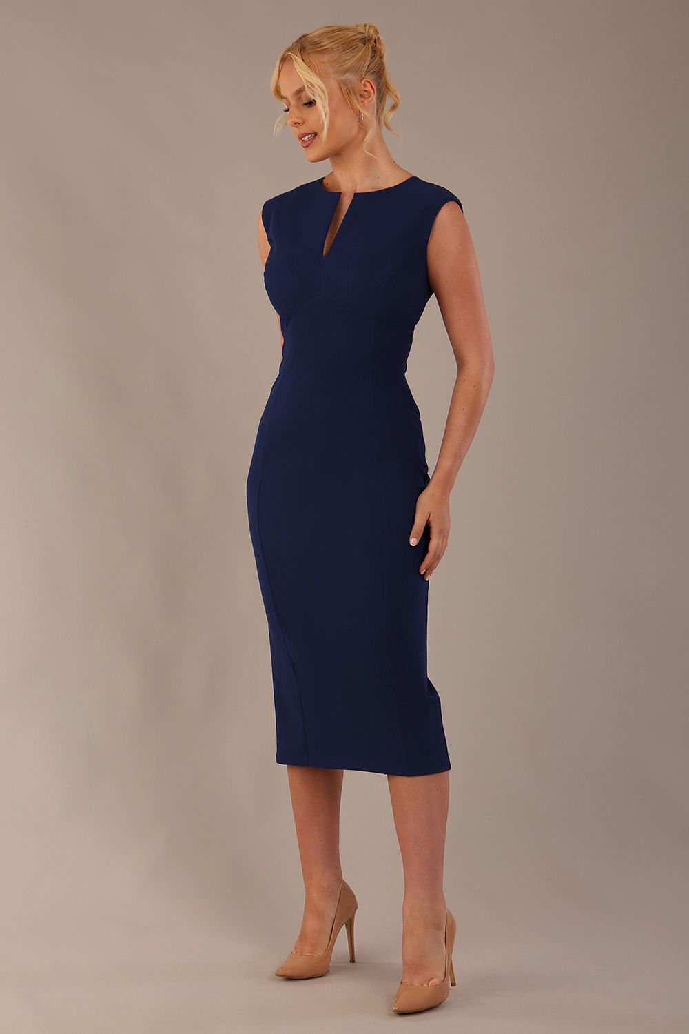 Model wearing the Wesley notched pencil dress in navy blue, showcasing the sculpted silhouette and V-notch neckline