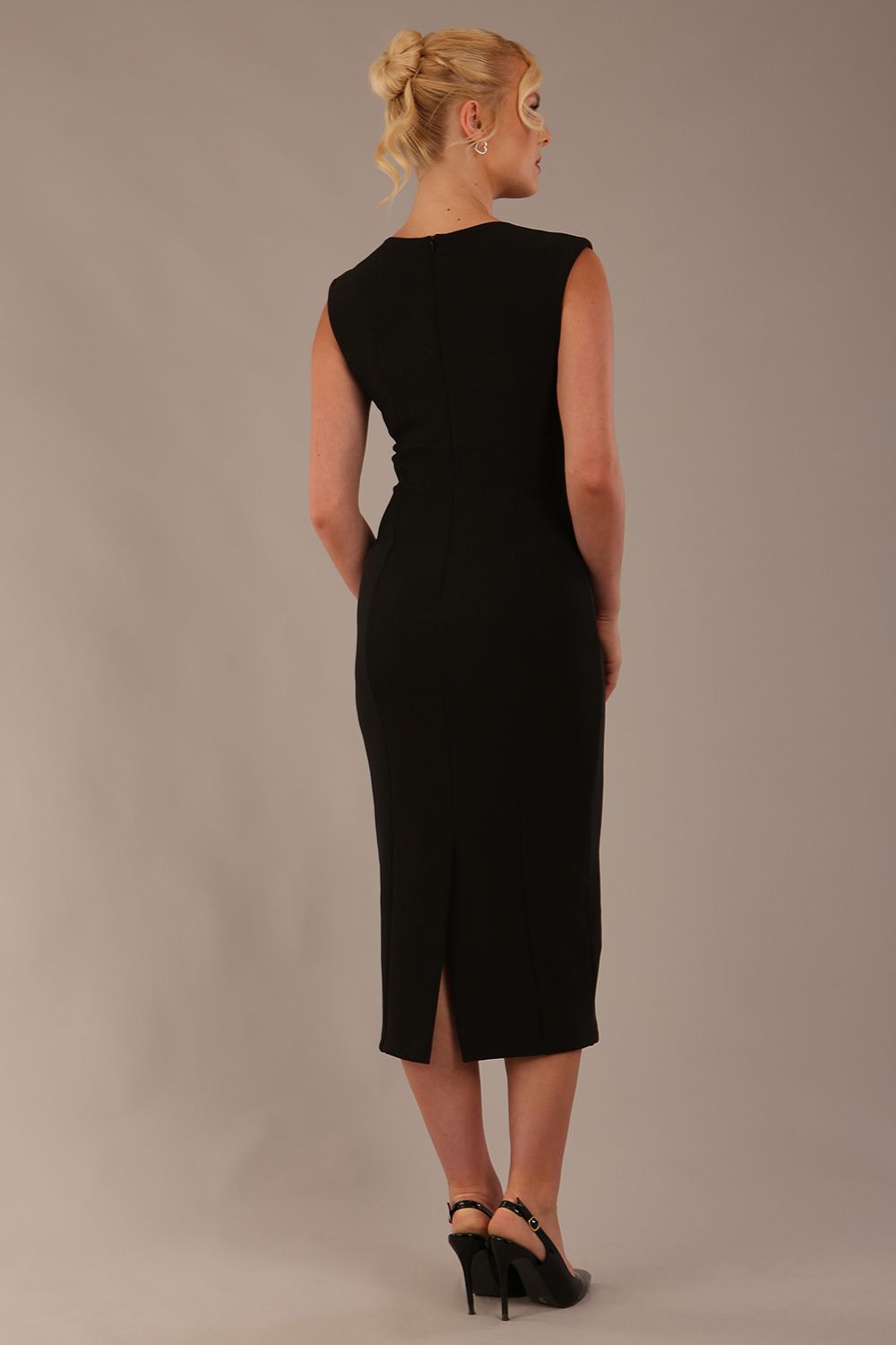 Model wearing the Wesley notched pencil dress in black, showcasing the sculpted silhouette and V-notch neckline back view