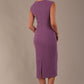 Model wearing the Wesley notched pencil dress in purple heart, showcasing the sculpted silhouette and V-notch neckline back view
