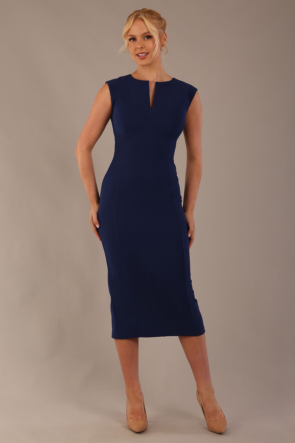Model wearing the Wesley notched pencil dress in navy blue, showcasing the sculpted silhouette and V-notch neckline