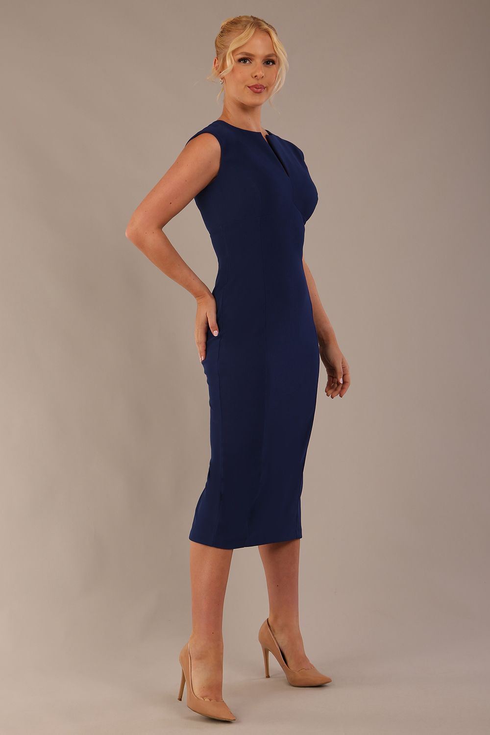 Model wearing the Wesley notched pencil dress in navy blue, showcasing the sculpted silhouette and V-notch neckline