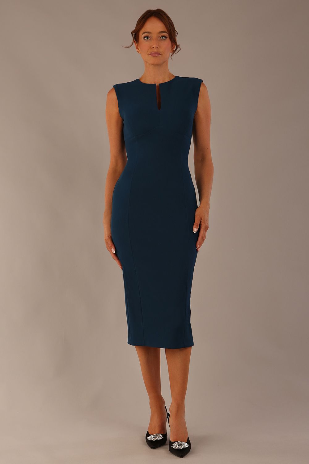 Model wearing the Wesley notched pencil dress in teal, showcasing the sculpted silhouette and V-notch neckline.