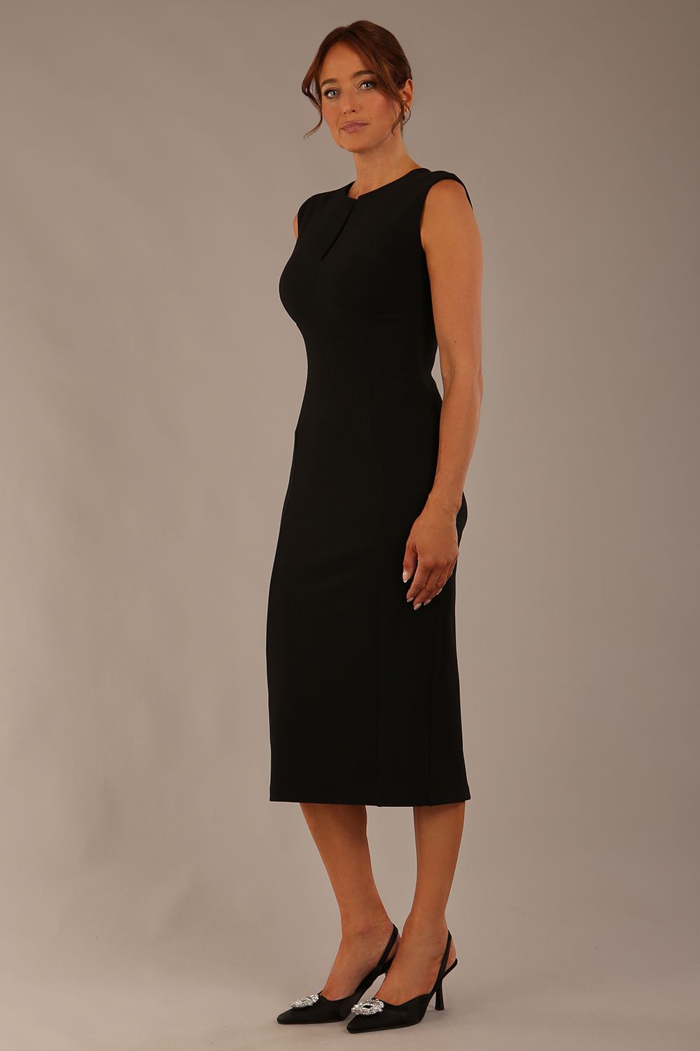 Model wearing the Wesley notched pencil dress in black, showcasing the sculpted silhouette and V-notch neckline.