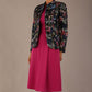 The Keanu floral jacket layered over a pink A-line dress for an elegant occasion look (Nightshade Bloom)