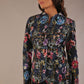 Model wearing the Keanu high-neck floral jacquard jacket styled with a navy pencil skirt (Nightshade Bloom)