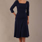 Model wearing the Rowan dress in navy blue, showing the square neckline and ruched bodice