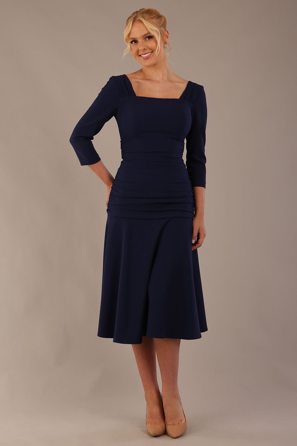 Model wearing the Rowan dress in navy blue, showing the square neckline and ruched bodice