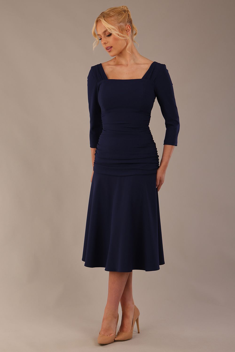 Model wearing the Rowan dress in navy blue, showing the square neckline and ruched bodice.
