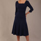 Model wearing the Rowan dress in navy blue, showing the square neckline and ruched bodice.