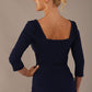 Model wearing the Rowan dress in navy blue, showing the square neckline and ruched bodice, back view