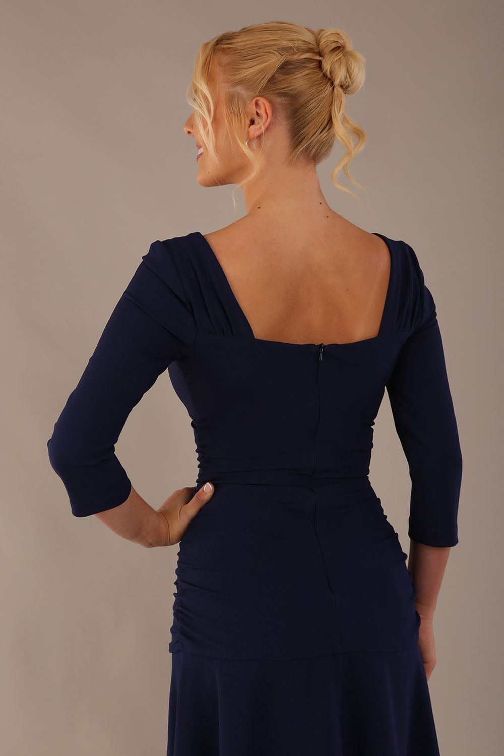 Model wearing the Rowan dress in navy blue, showing the square neckline and ruched bodice, back view
