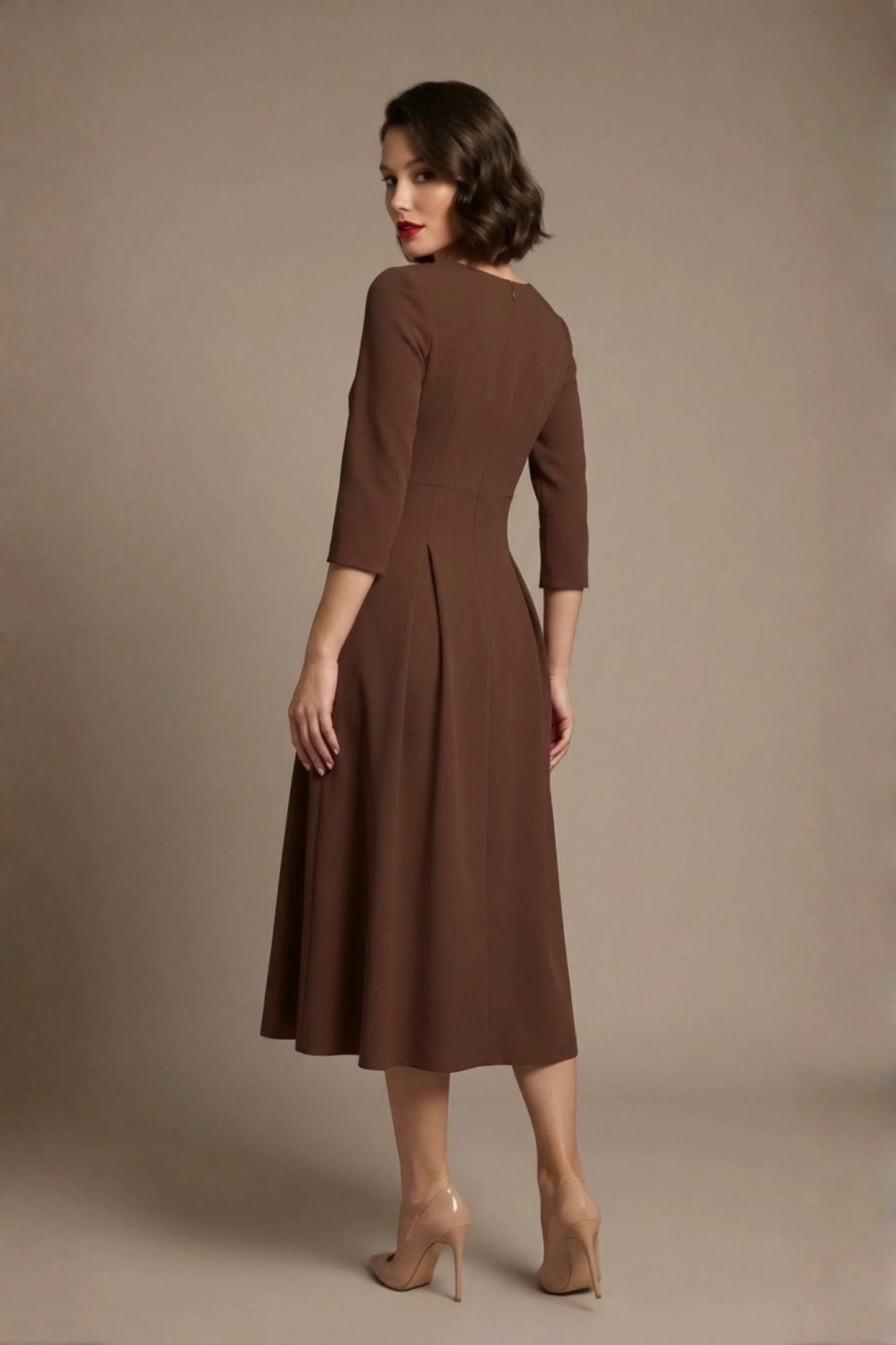 Woman wearing a diva catwalk Amanda Pleated a-line dress in a magenta pink colour against a beige background (Peppercorn Brown)