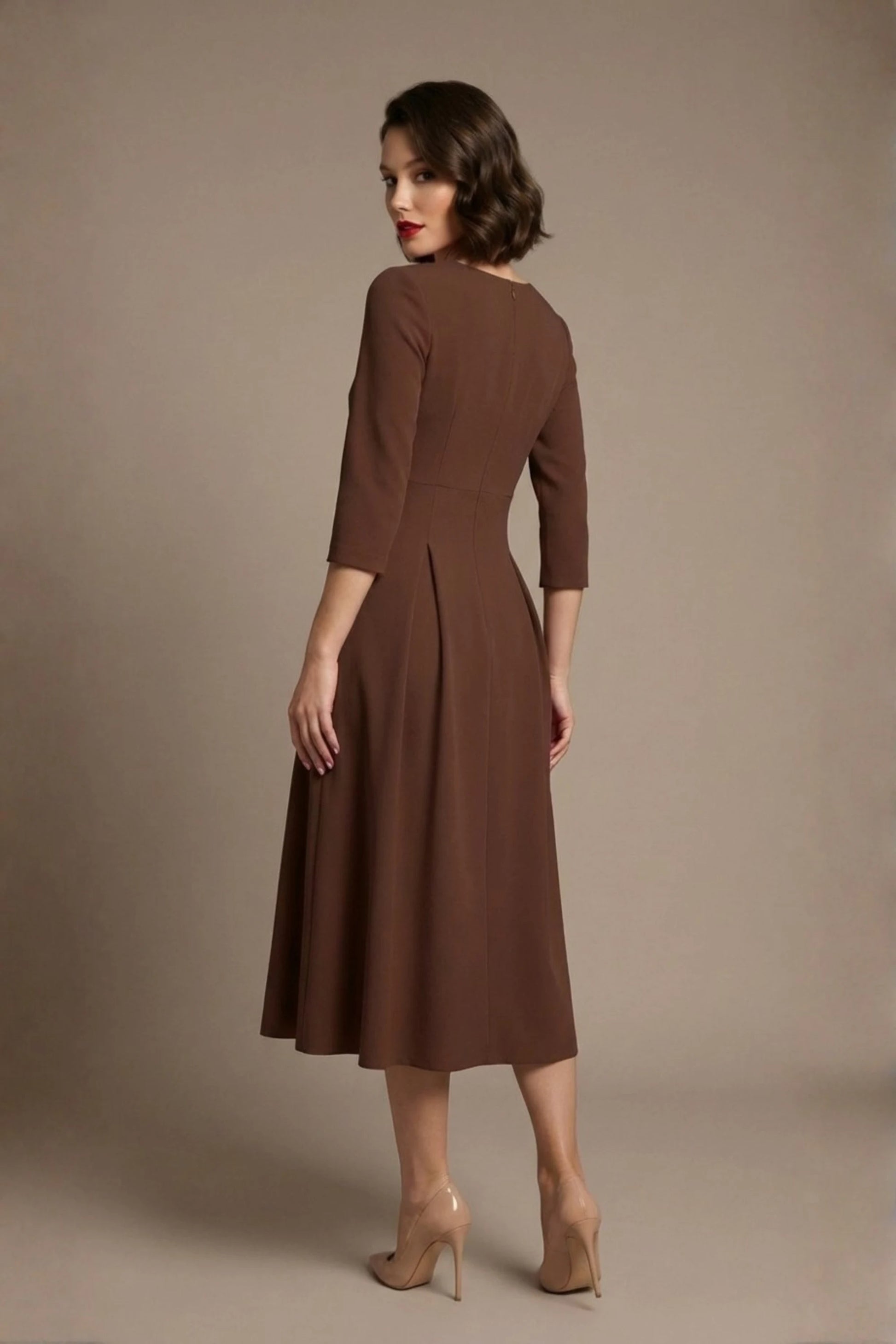 Woman wearing a diva catwalk Amanda Pleated a-line dress in a magenta pink colour against a beige background (Peppercorn Brown)