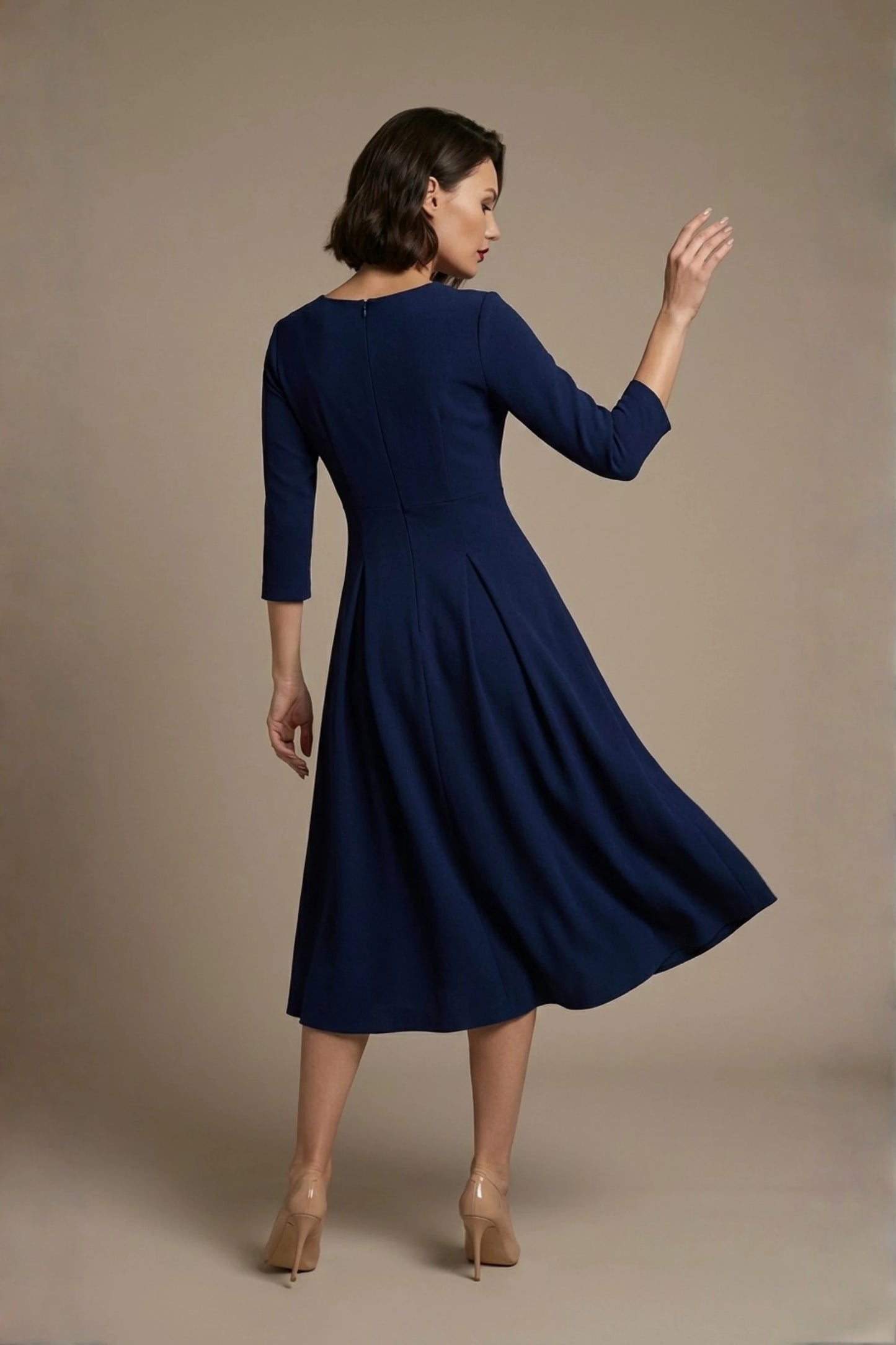 Woman wearing a diva catwalk Amanda Pleated a-line dress in a magenta pink colour against a beige background (Navy Blue)