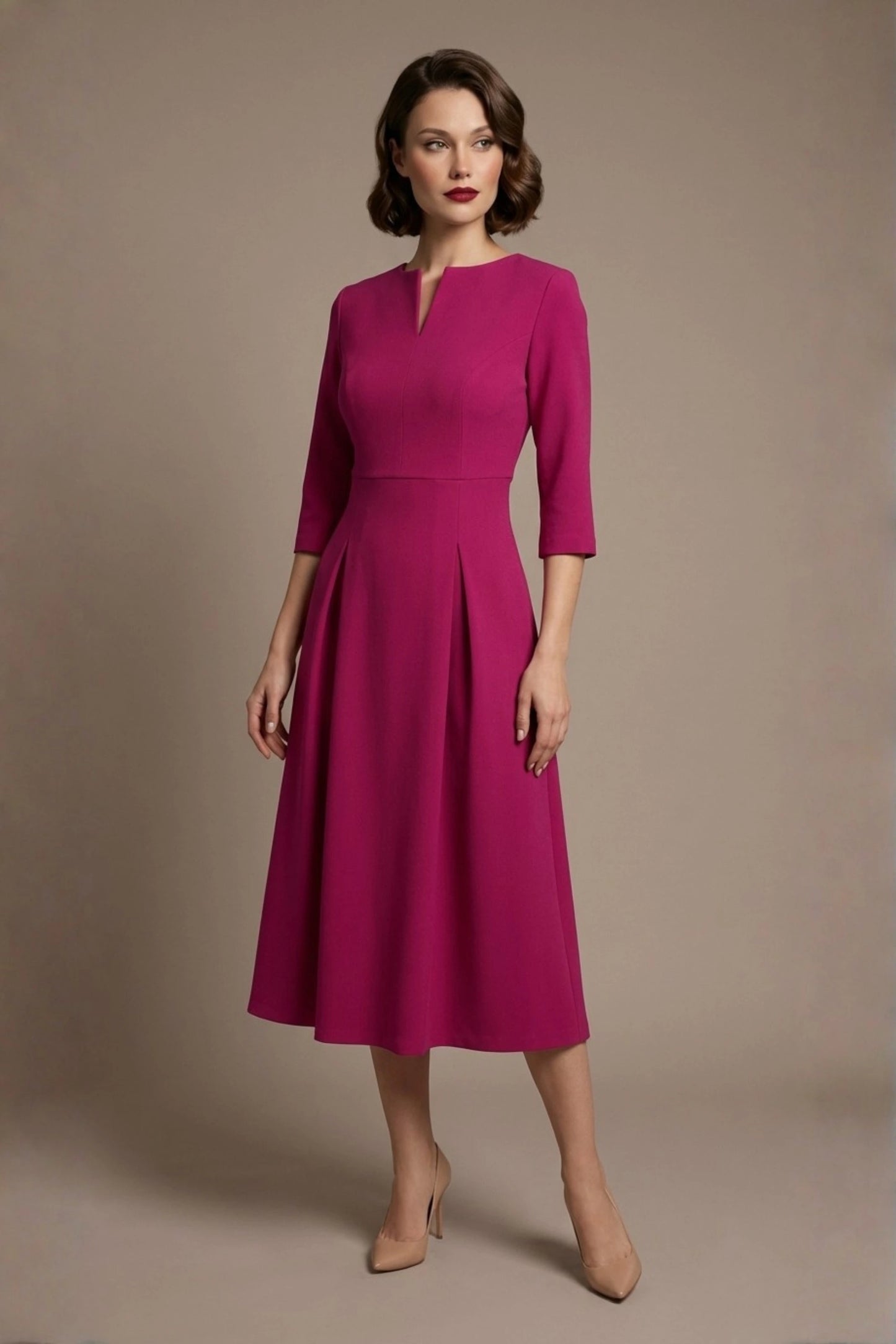 Woman wearing a diva catwalk Amanda Pleated a-line dress in a magenta pink colour against a beige background (Magenta)