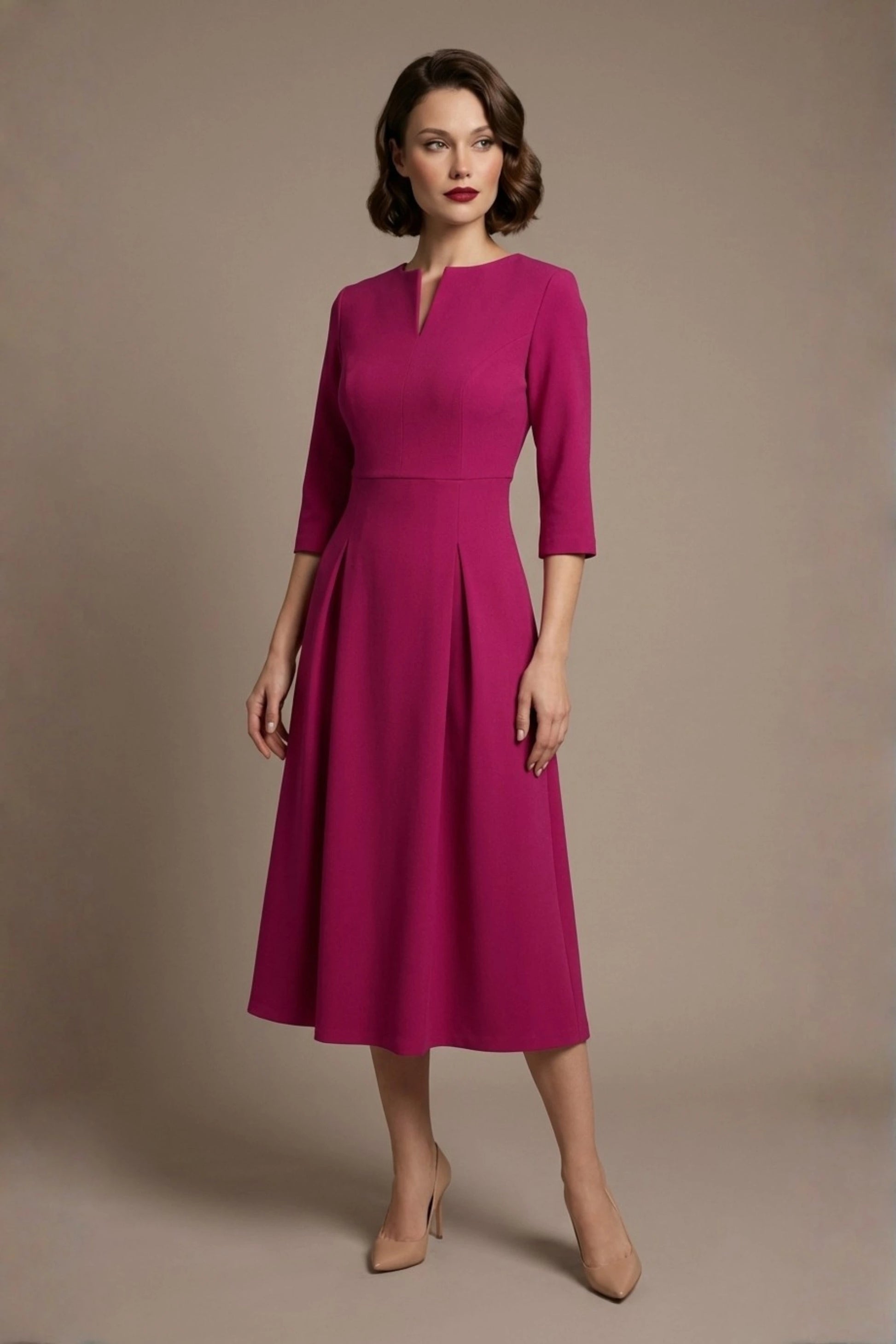Woman wearing a diva catwalk Amanda Pleated a-line dress in a magenta pink colour against a beige background (Magenta)