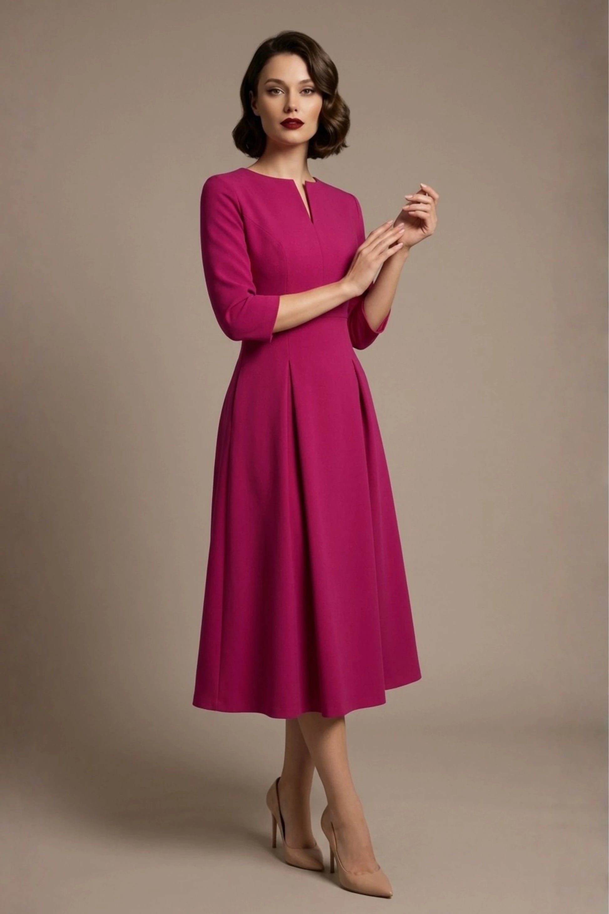 Woman wearing a diva catwalk Amanda Pleated a-line dress in a magenta pink colour against a beige background (Magenta)