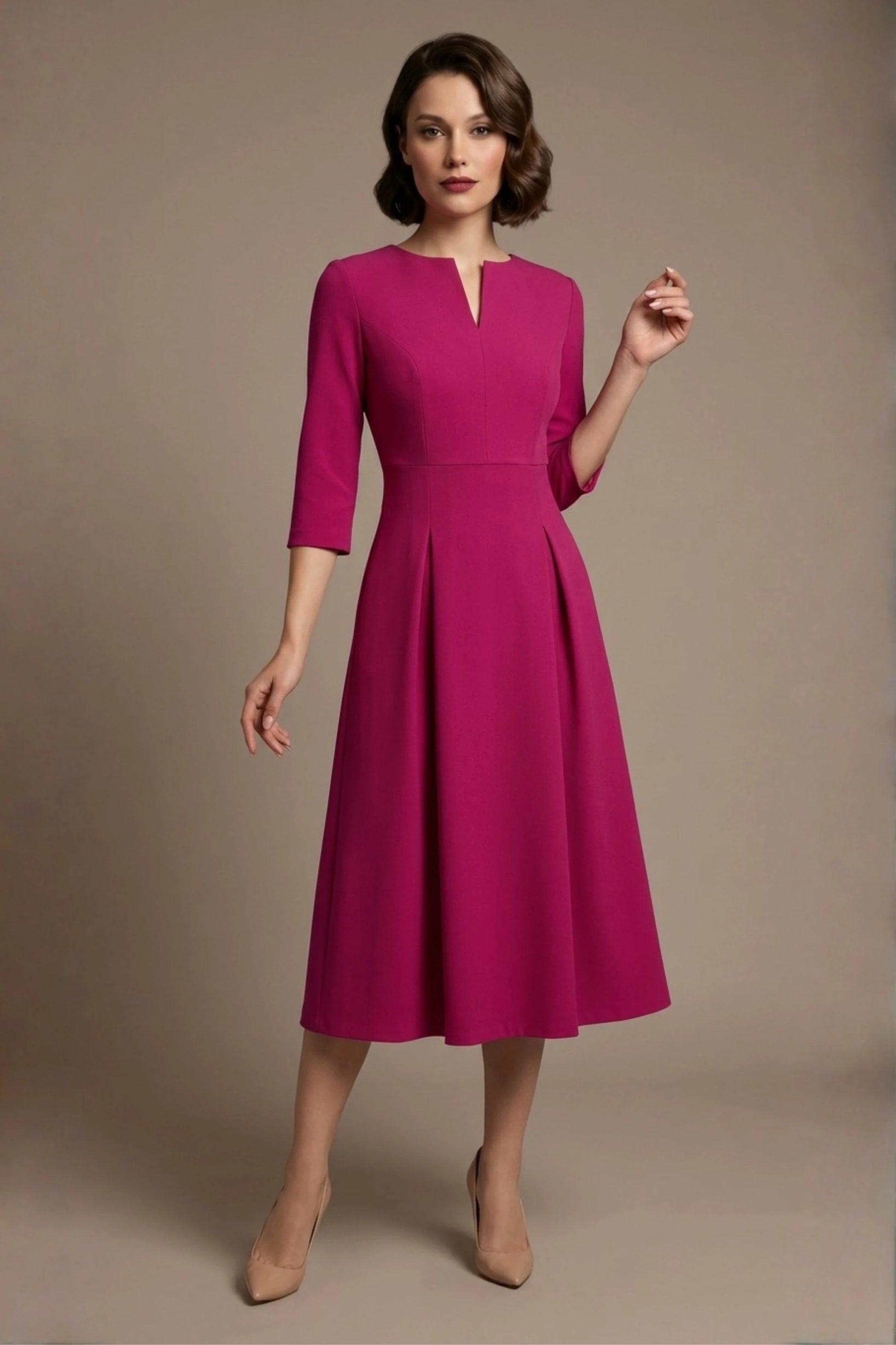 Woman wearing a diva catwalk Amanda Pleated a-line dress in a magenta pink colour against a beige background (Magenta)