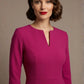 Woman wearing a diva catwalk Amanda Pleated a-line dress in a magenta pink colour against a beige background (Magenta)